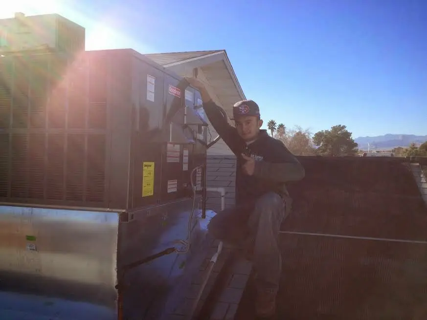 HVAC technician performing Air Duct Cleaning on a rooftop unit in Granite City